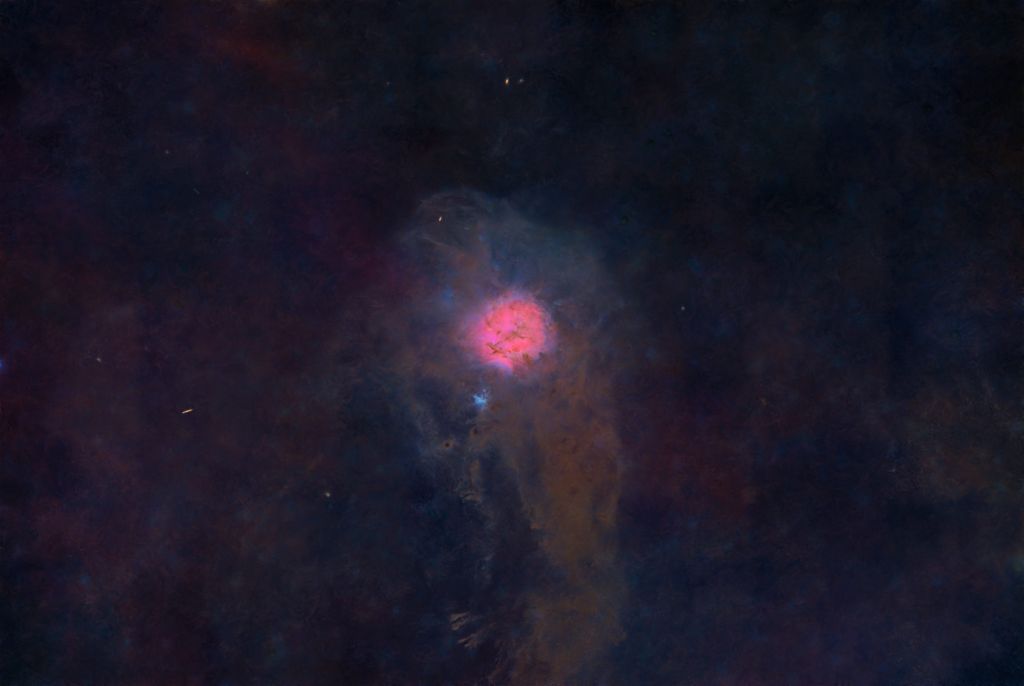 A vibrant nebula with swirling colors, primarily deep blues and purples, featuring a bright pink center glowing against a dark cosmic background.